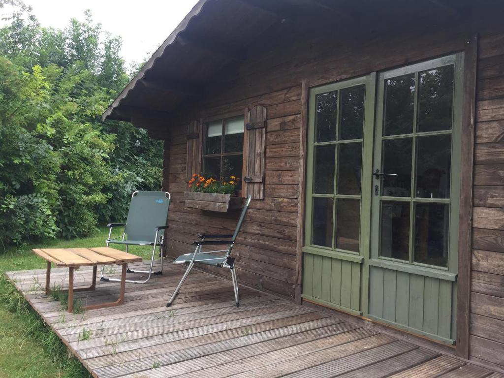 a cabin with a table and chairs on a deck at VierVaart Veldhuisje TERRA in Groede