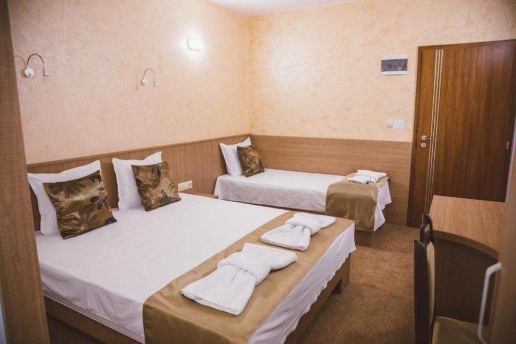 a hotel room with two beds with towels on them at Стаи за гост Хит Хаус и СПА in Bratsigovo