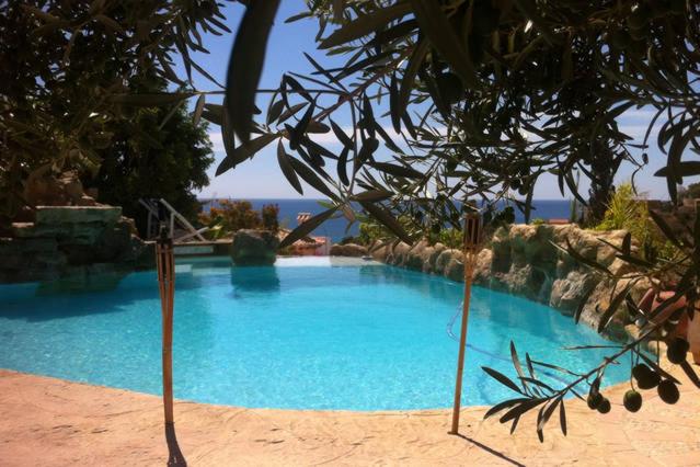 une grande piscine bleue à côté de l'océan dans l'établissement Apartamento Alba Beach, à Alicante