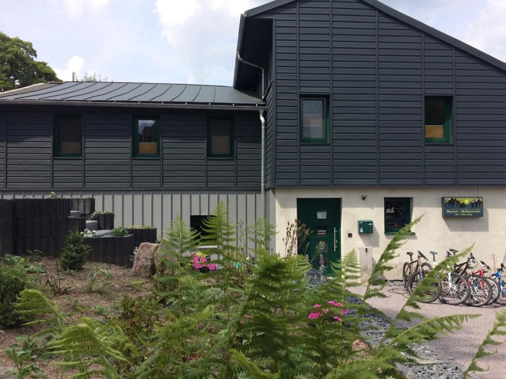 a black house with bikes parked outside of it at Pension SPORT-SCHMIEDE in Schmiedefeld am Rennsteig