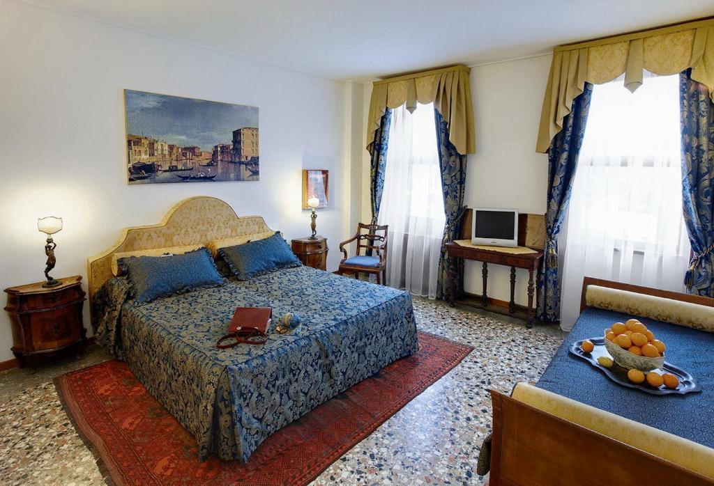 um quarto com uma cama e uma mesa com um prato de fruta em Ca' Angeli em Veneza