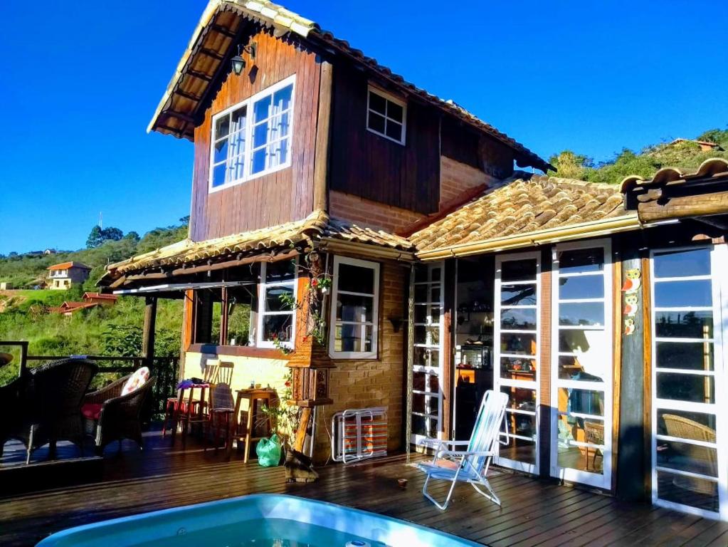 uma casa com um deque e uma piscina em Casinha do Up em Conceição do Ibitipoca