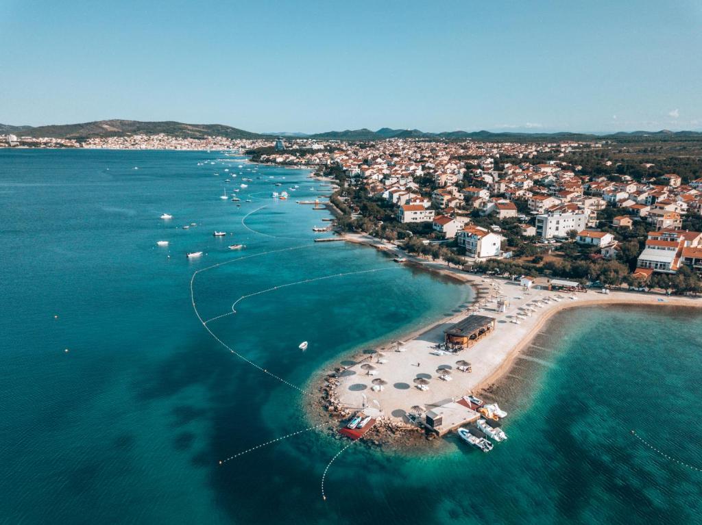 een luchtzicht op een strand met boten in het water bij Pansion Karoca in Vodice