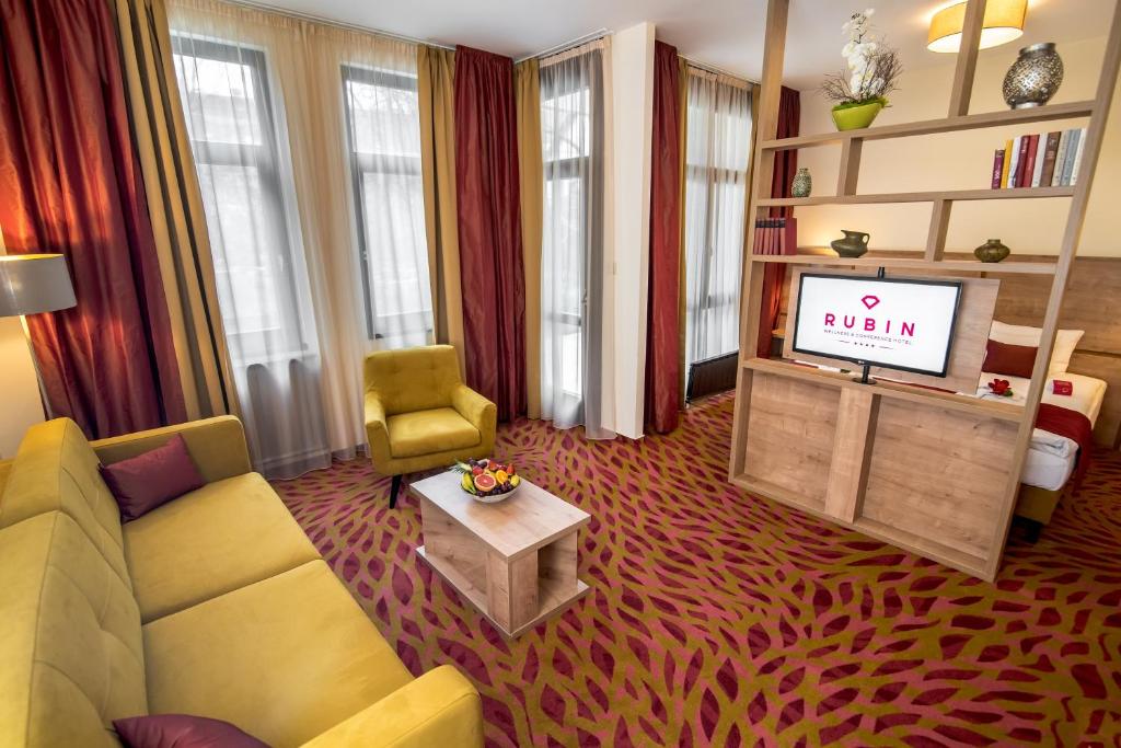 a living room filled with furniture and a tv at Rubin Wellness & Conference Hotel in Budapest