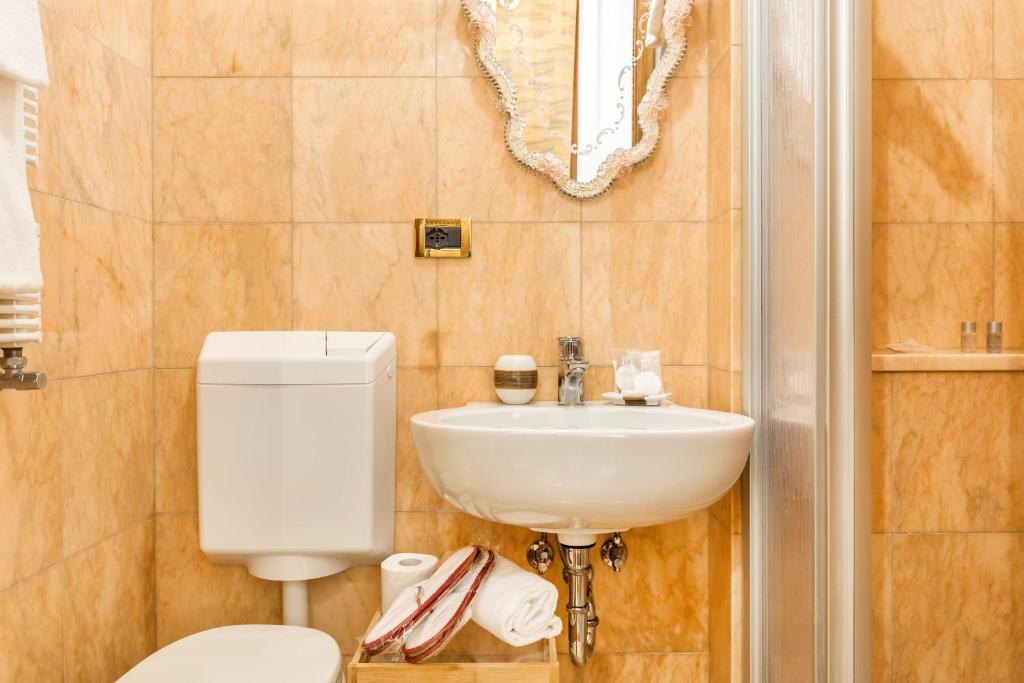a bathroom with a toilet and a sink at Luxury Venetian Rooms in Venice