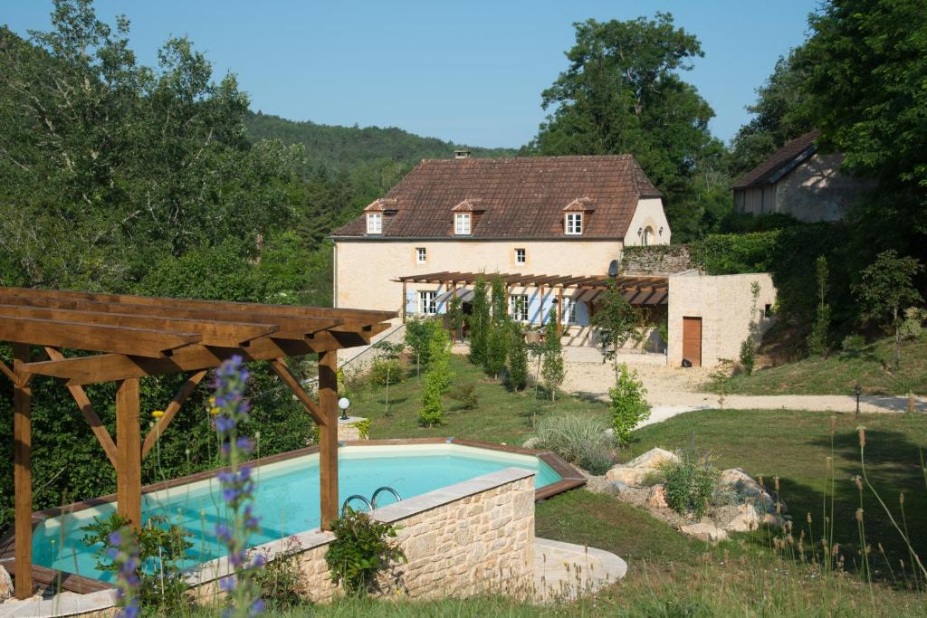 a house with a swimming pool in a yard at Maison du Cèdre in Auriac-du-Périgord