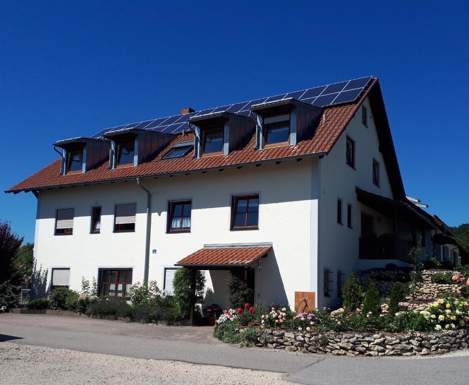 una casa bianca con pannelli solari sul tetto di Ferienwohnung Weigert a Sinzing