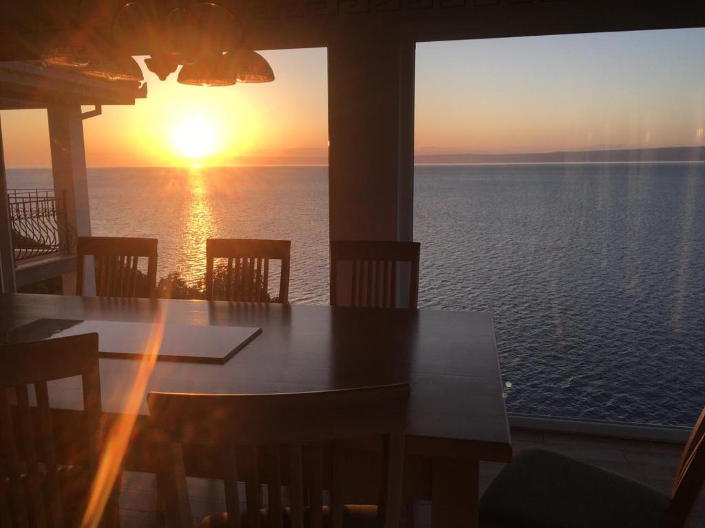 un tavolo con vista sull'oceano al tramonto di THE VIEW **** a Račišće