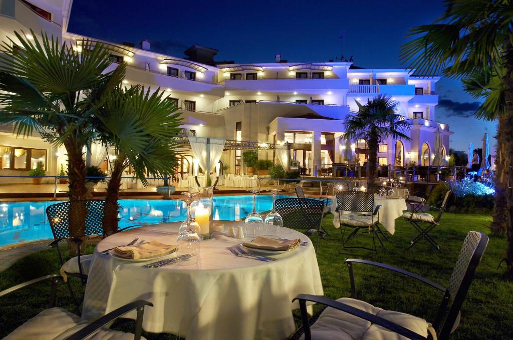 a restaurant with a table and chairs in front of a building at Aeton Melathron Hotel in Tríkala