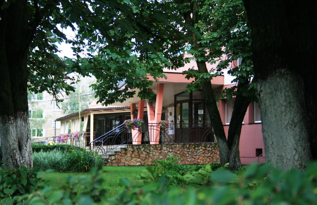 a pink house with a porch and stairs to it at Polist Hotel in Staraya Russa
