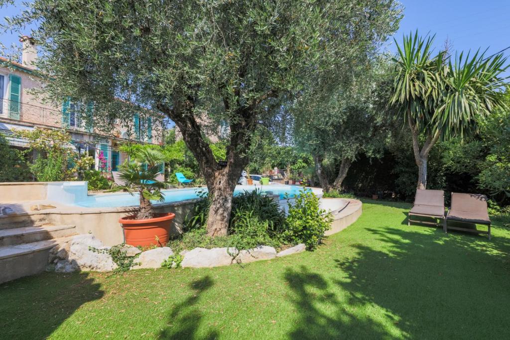 a yard with a tree and a swimming pool at Vencianne in Vence