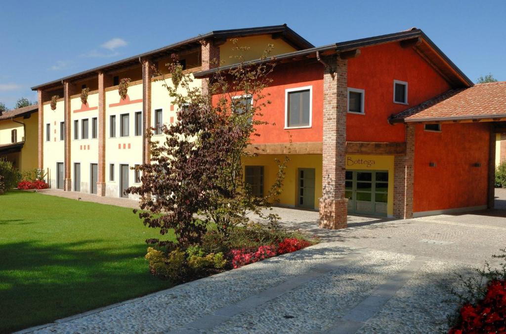 un gran edificio rojo y blanco con un patio verde en Agriturismo I Leprotti, en Abbiategrasso