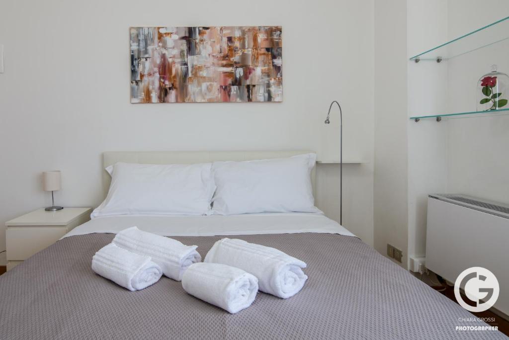 a bed with three towels on top of it at YPA APARTMENTS STORIONE in Padova