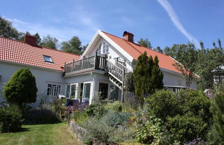 een groot wit huis met een balkon in een tuin bij Apartment in the countryside in Tossene Hunnebostrand in Hunnebostrand