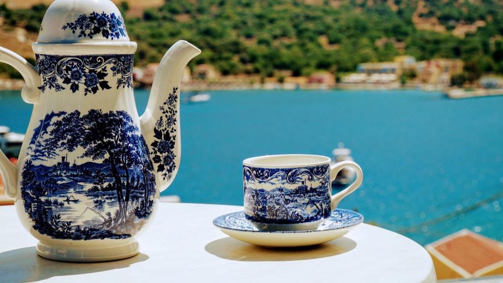 a blue and white vase and a cup on a table at Irene Double Apartment Katoi in Symi