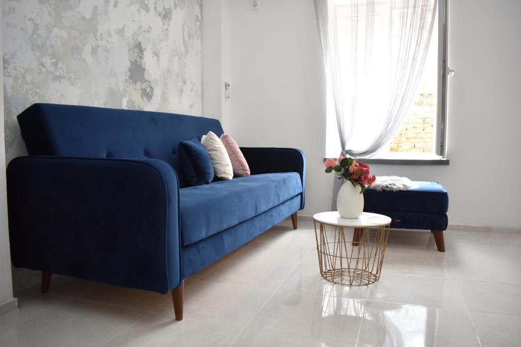Sofá azul en la sala de estar con mesa en Art Apartments, en Kotor