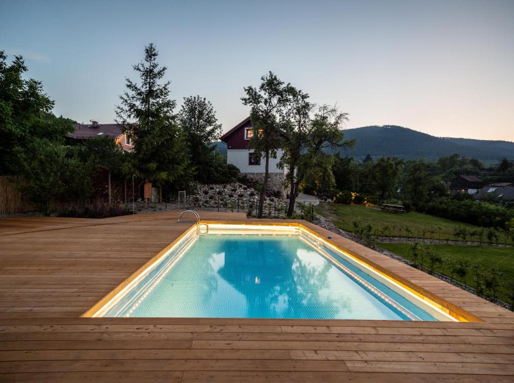 a swimming pool on a deck with a house at Willa Wzgórze Poręba in Długopole-Zdrój