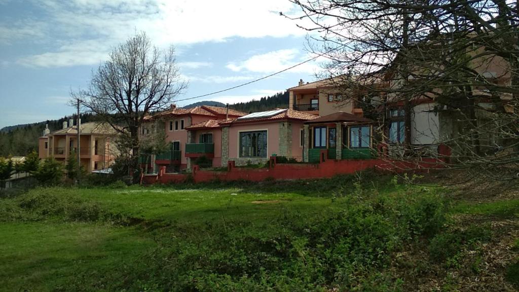 dom siedzący na trawiastym polu przed nim w obiekcie Oreiades Houses w mieście Kardítsa