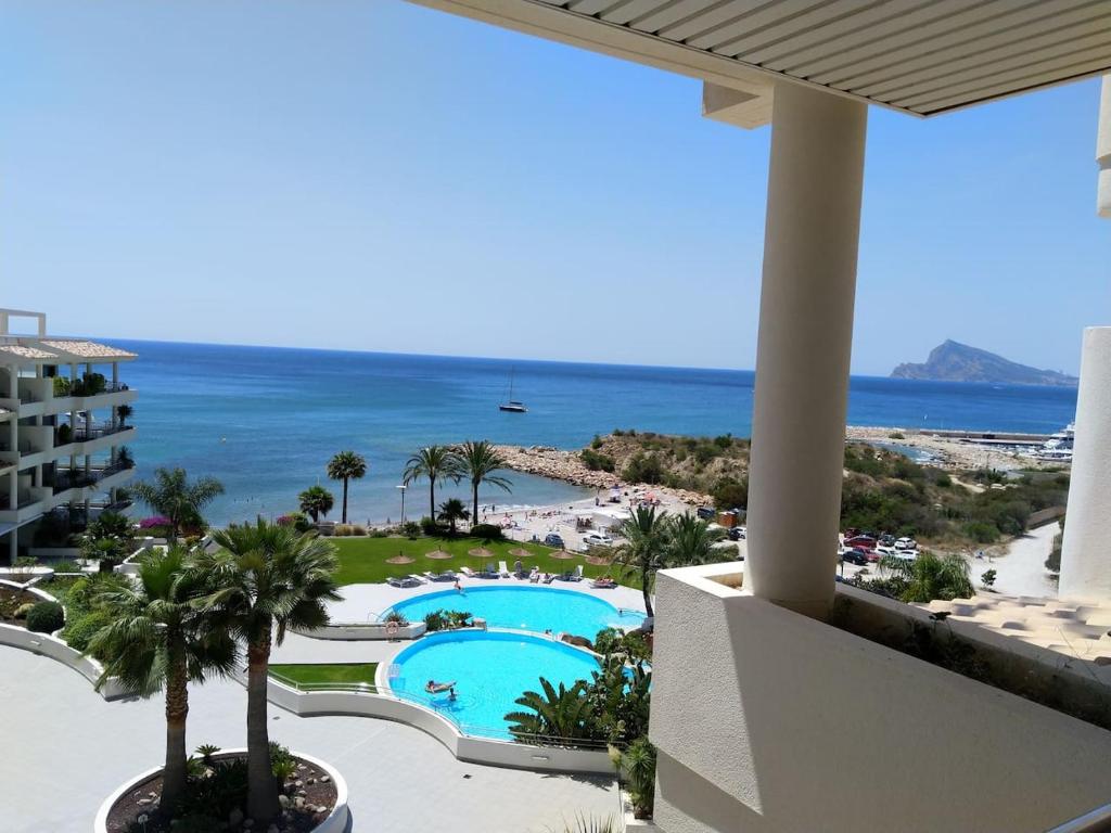 een balkon met uitzicht op het zwembad en het strand bij MASCARAT BEACH in Altea