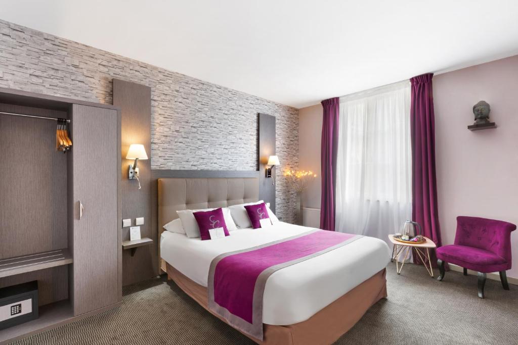 a hotel room with a large bed and a purple chair at Best Western Hotel Saint Claude in Péronne