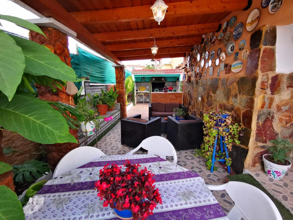 a patio with two tables and chairs and plants at Chalet Santa Oliva in Santa Oliva