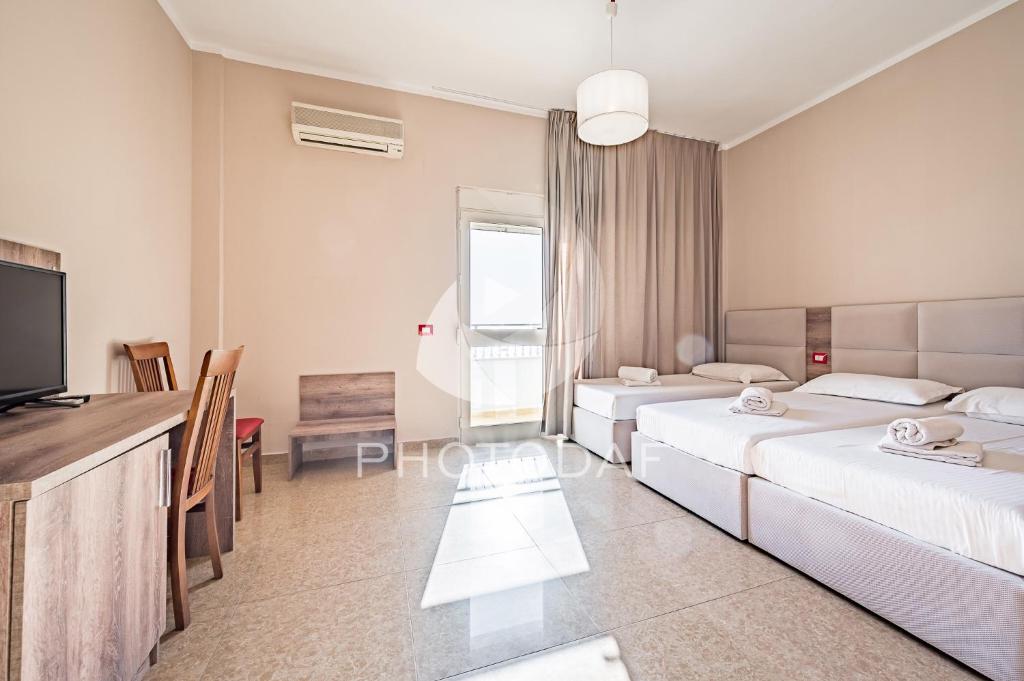 a hotel room with two beds and a flat screen tv at Inn Hotel in Durrës