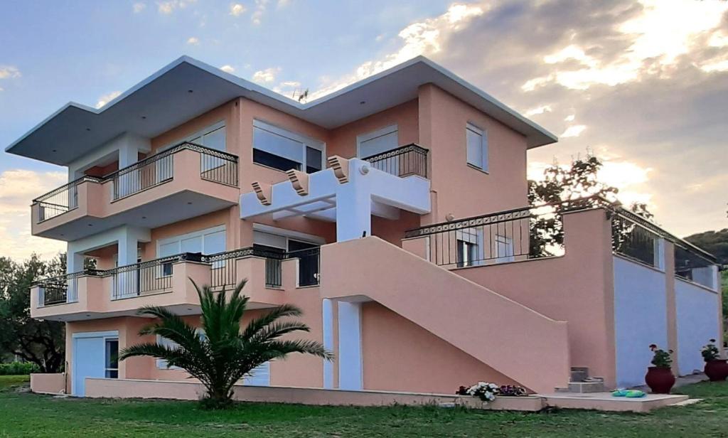 un edificio rosa con una cruz en el costado. en Chris Lux en Ormos Panagias