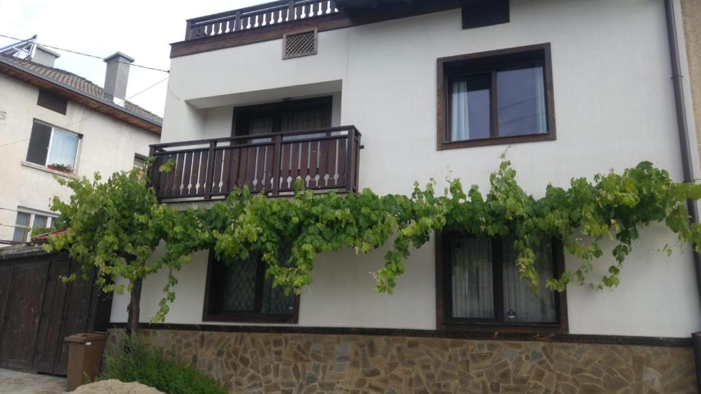 une maison blanche avec des fenêtres noires et une clôture dans l'établissement Relax, à Dobrinichte