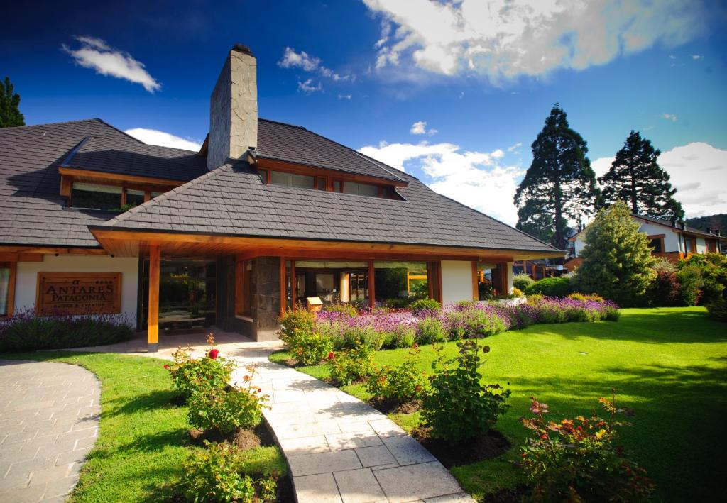 una casa con un jardín delante de ella en Casa Antares Patagonia en San Martín de los Andes
