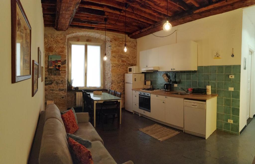uma cozinha com um sofá e uma mesa num quarto em Il Mezzero all' Acquario em Gênova