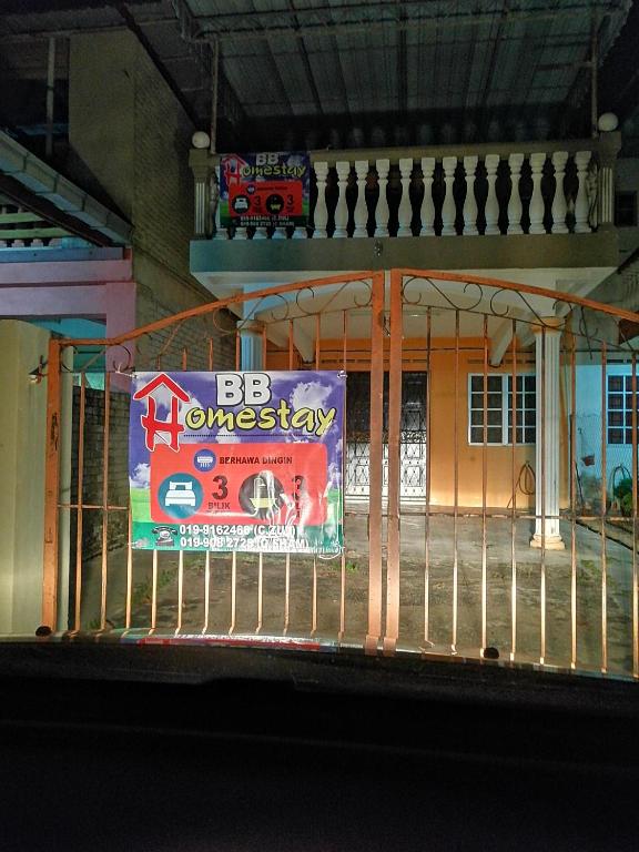 a sign on a fence in front of a building at BB HOMESTAY in Kampung Tualang