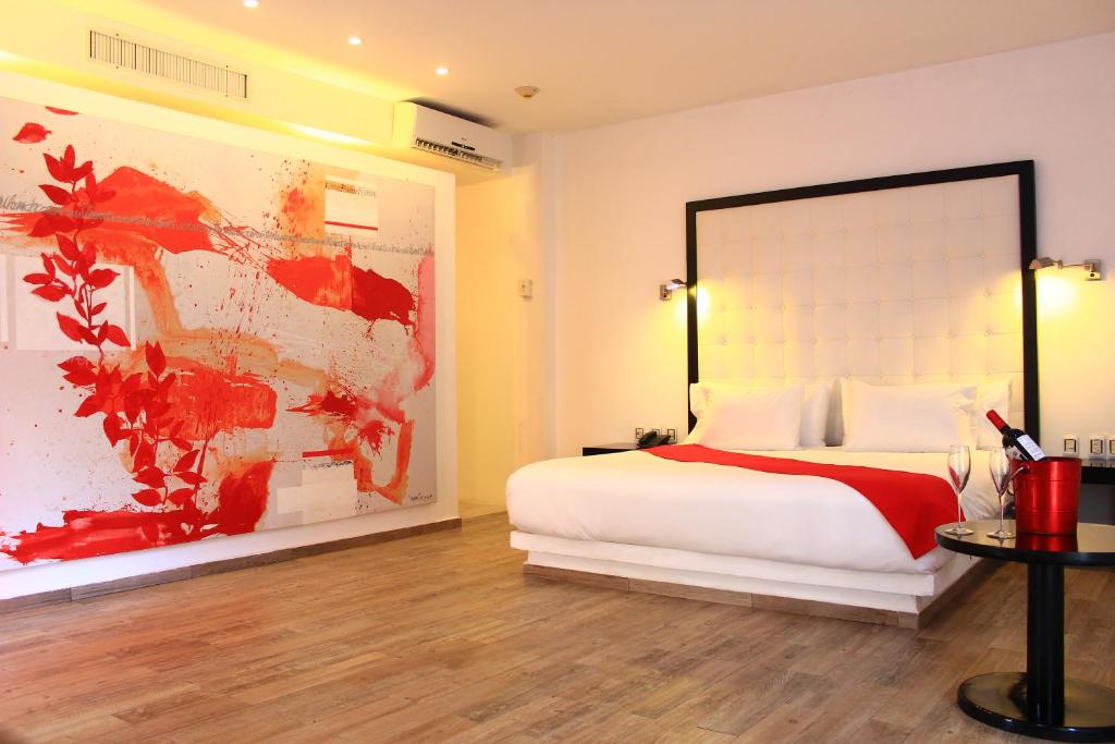 una camera da letto con un letto e un dipinto sul muro di In Fashion Hotel & Spa a Playa del Carmen