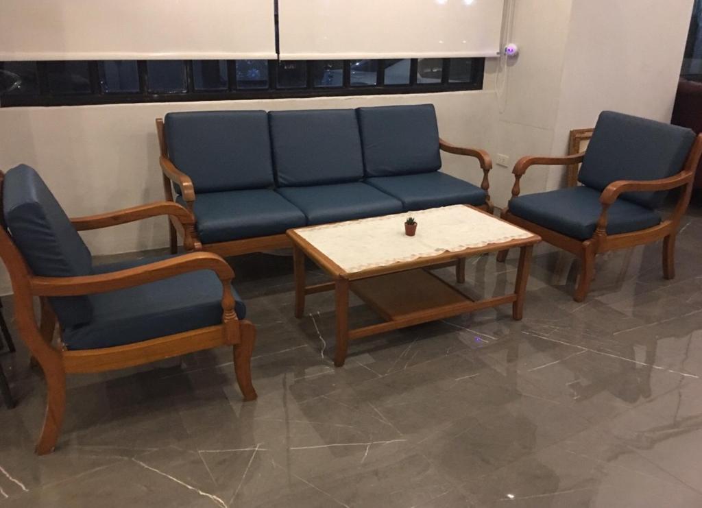 A formal waiting area offers a three-seat sofa, armchairs and a low coffee table.