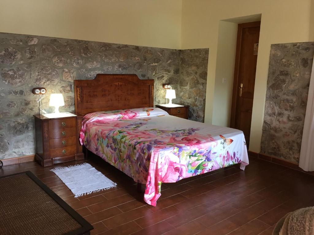 a bedroom with a bed and two night stands with lamps at Camangu-Estudio in Ribadesella