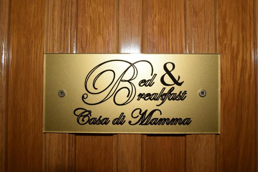 a sign on a wooden door with a sign on it at B&B Casa di Mamma in Corato