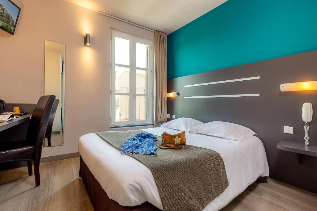 a hotel room with a large bed with a blue wall at Hotel Terminus Saint-Charles in Marseille