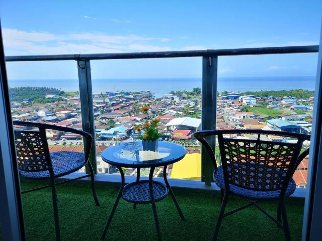 a table and chairs on a balcony with a view at Sekinchan High Level SeaView Homestay in Sekincan