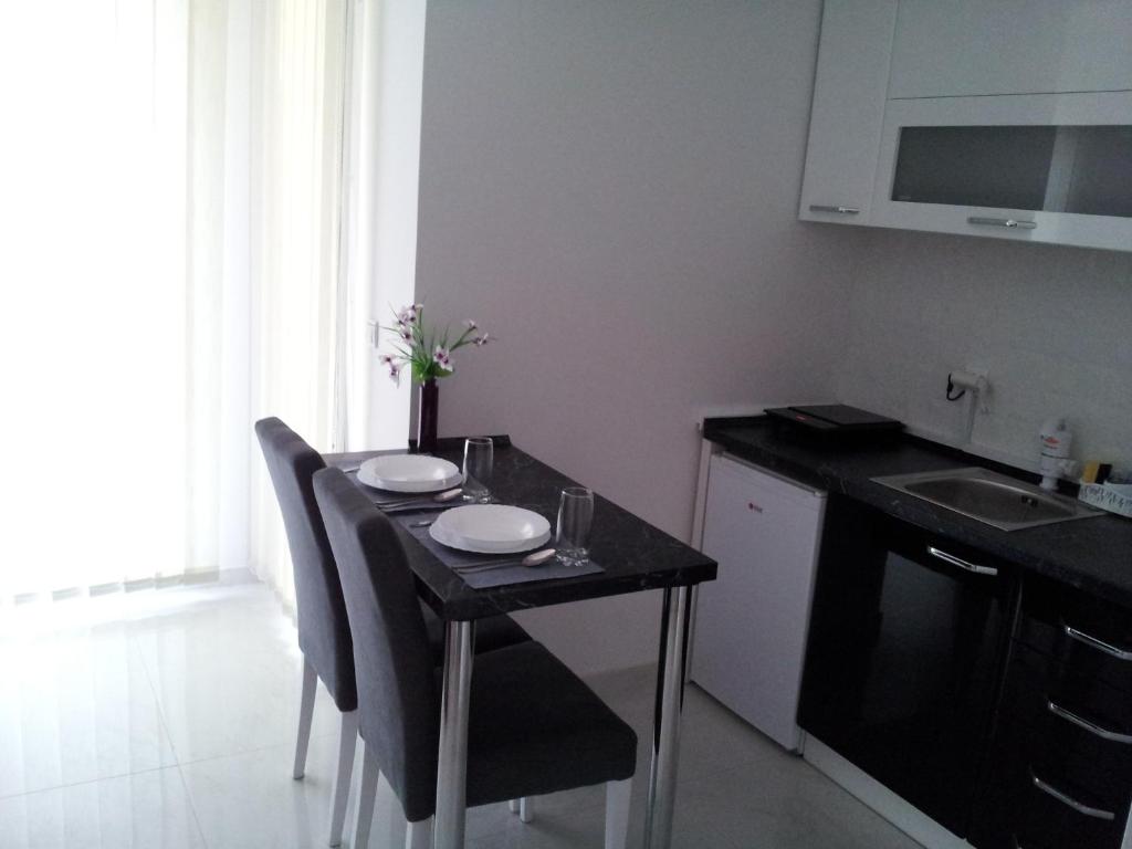 a small kitchen with a table with two plates on it at Apartmani MITIĆ in Veliko Gradište