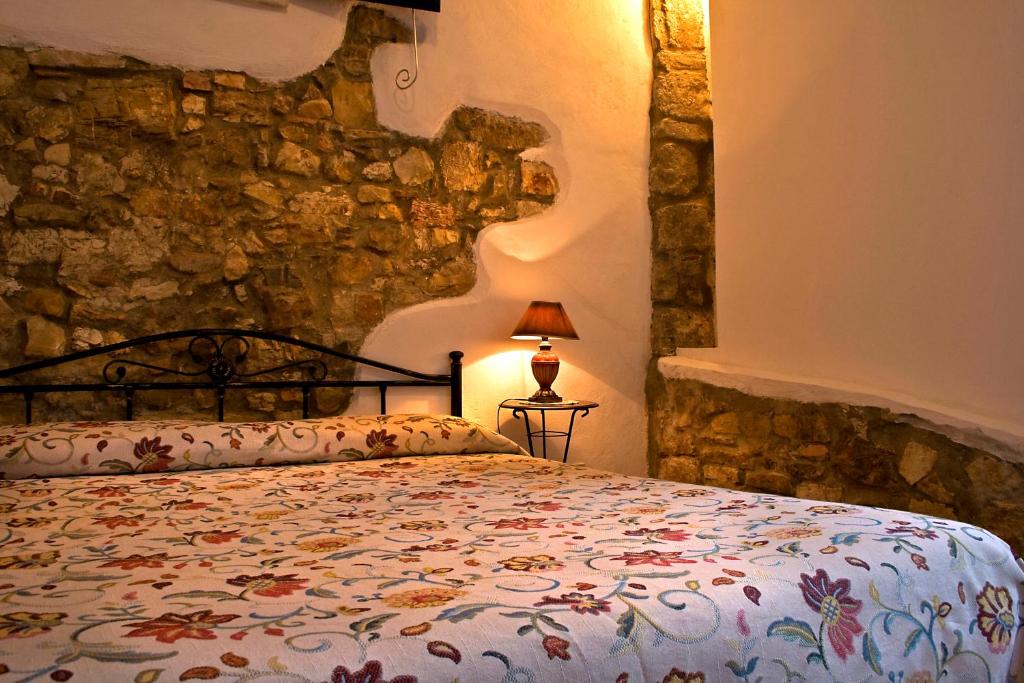 una camera con un letto e un muro in pietra di Xanadu - Villa Giardinata a Valderice