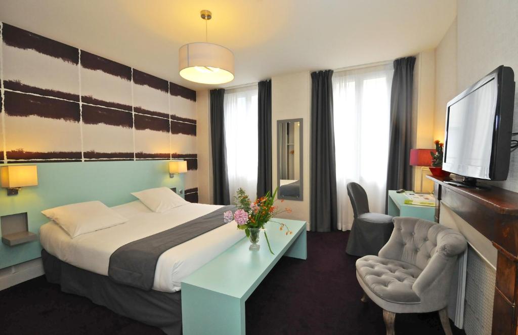 バレージュにあるLogis Hôtel Le Centralのベッドとテレビが備わるホテルルームです。