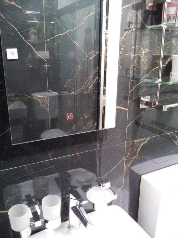 a bathroom with a sink and a mirror and a toilet at Apartmani MITIĆ in Veliko Gradište