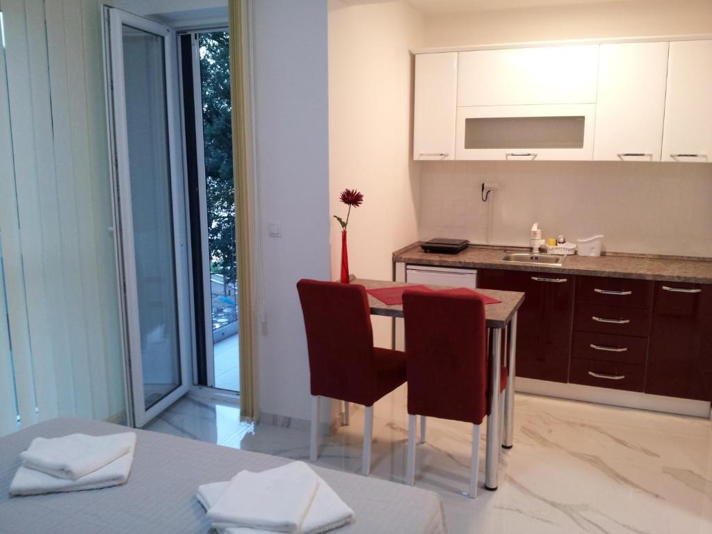 a kitchen with a table and chairs and a sink at Apartmani MITIĆ in Veliko Gradište