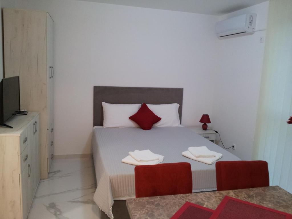 a bedroom with a large bed with red pillows at Apartmani MITIĆ in Veliko Gradište