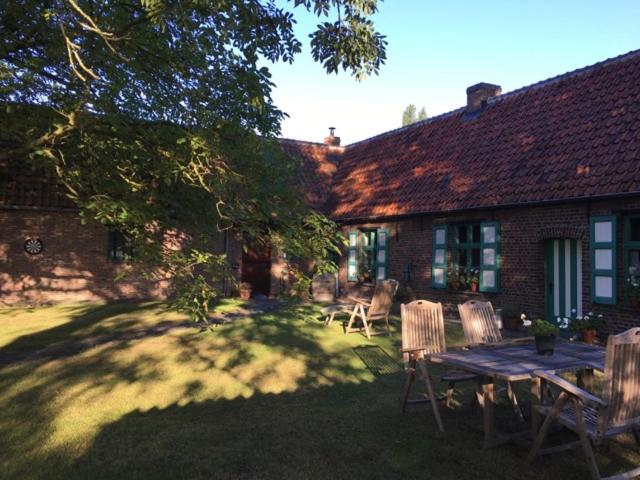 una casa con mesa de picnic y sillas en el patio en Ma Campagne, en Heusden