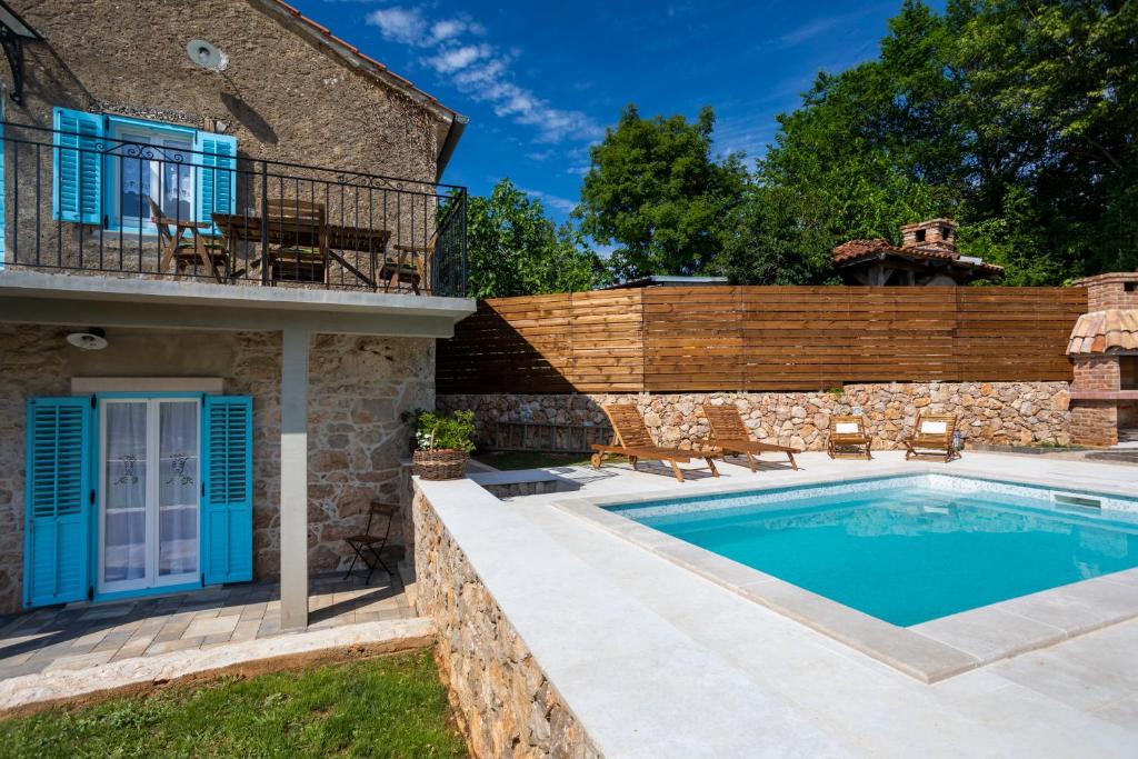 - une piscine en face d'une maison dans l'établissement Stone Villa Katarina with pool, à Klimno