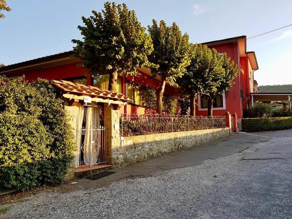 un edificio rosso con recinzione accanto a una strada di Al Borgo a Lucca