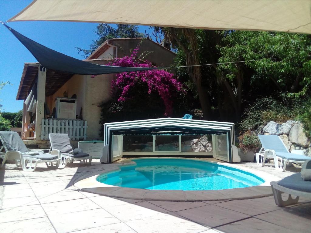 a swimming pool with an umbrella next to a house at Villa La Désirade in Antibes