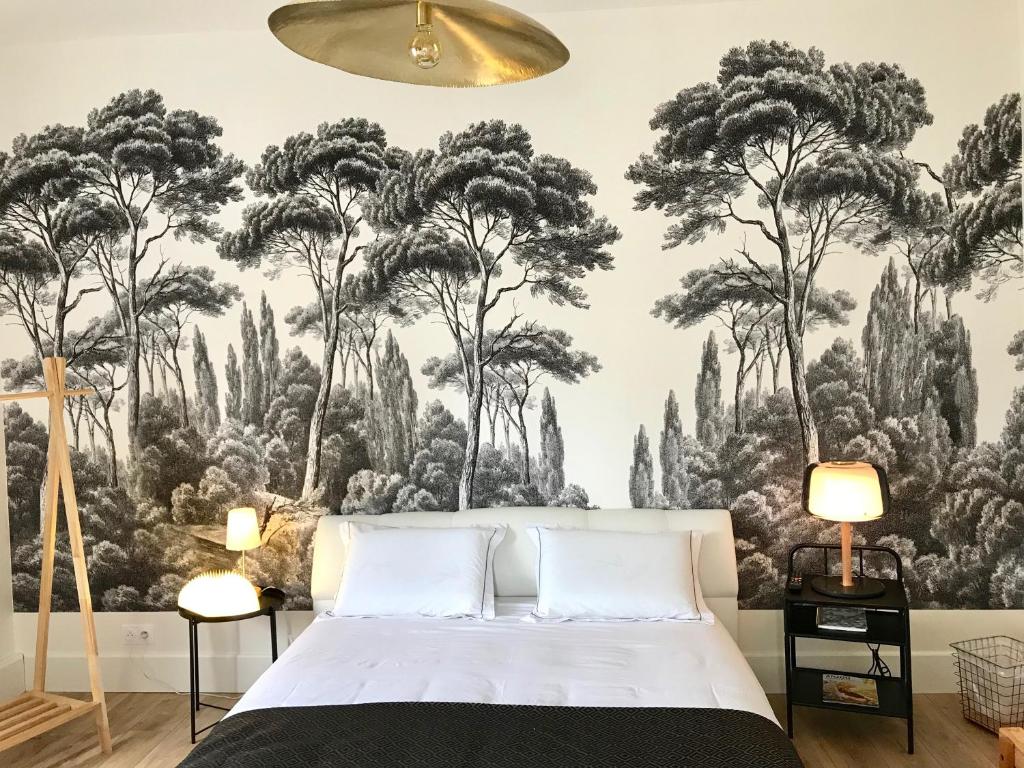 a bedroom with a large mural of trees on the wall at La Lambertine & Spa in Saumur
