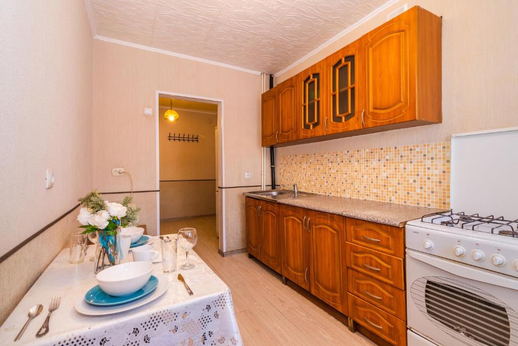 uma cozinha com armários de madeira e um forno de fogão branco em Buzkvartira on 2 microrayon em Buzuluk