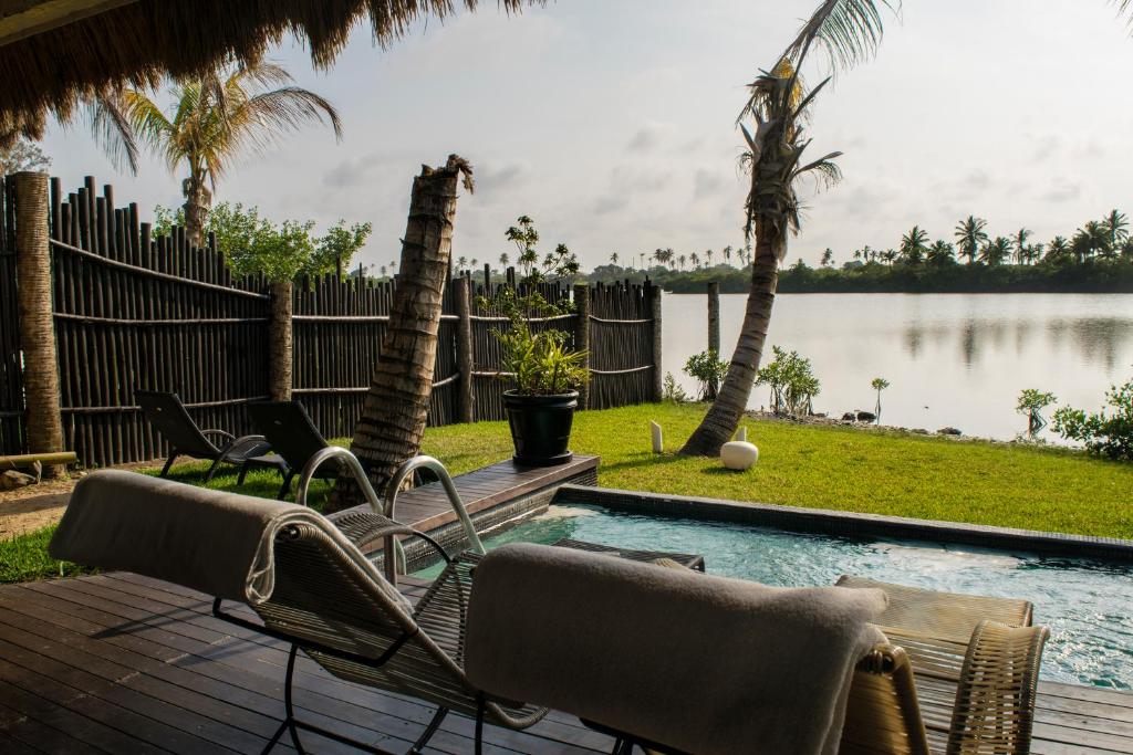 une terrasse avec des chaises et une piscine offrant une vue sur l'eau dans l'établissement Isla Tajín, à Tuxpan